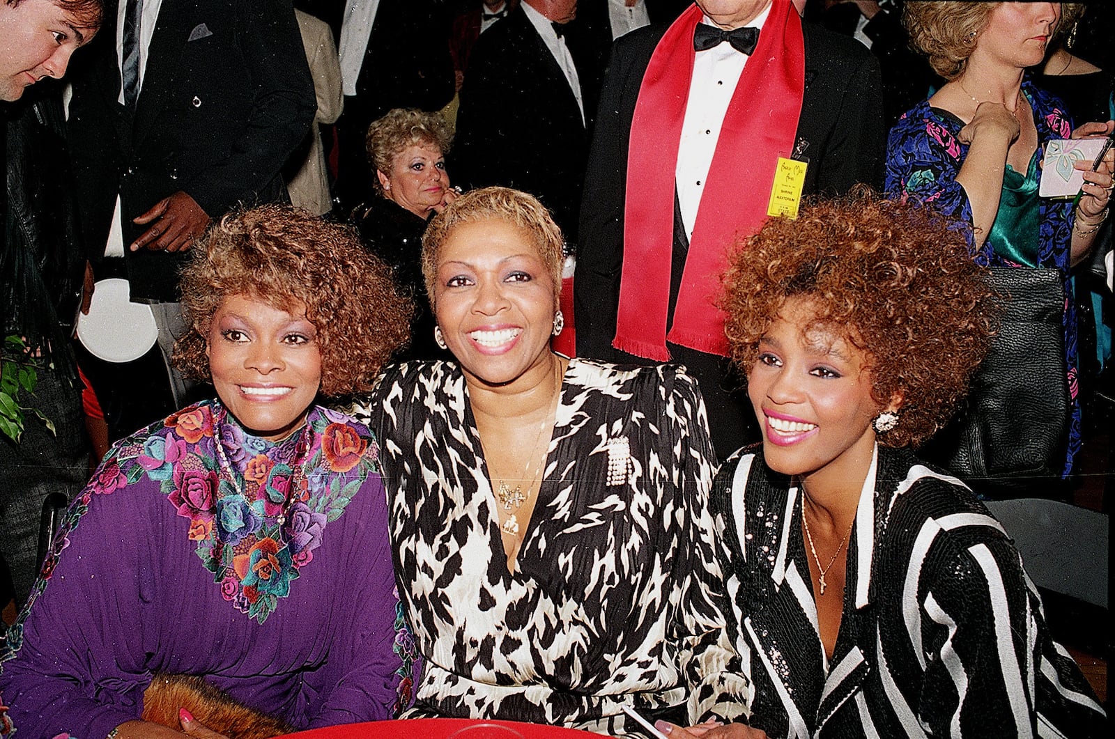 Whitney Houston, right, sits with her cousin Dionne Warwick, left, and her mother, gospel singer Cissy Houston, center, after the American Music Awards at the Shine Auditorium in Los Angeles, Jan. 26, 1987.  (AP Photo/Lennox McClendon)