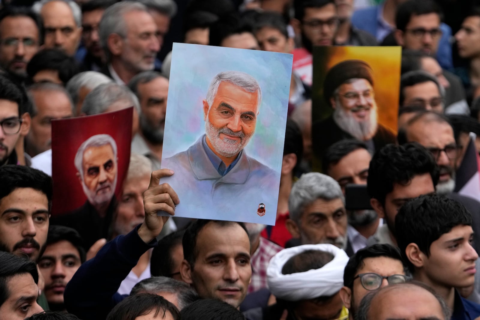 Iranian demonstrators hold up posters of the late Revolutionary Guard Gen. Qassem Soleimani, center and left, who was killed in Iraq in a U.S. drone attack in 2020, and the late Hezbollah leader Hassan Nasrallah, who was killed in an Israeli airstrike in Beirut in September, during an annual rally in front of the former U.S. Embassy in Tehran, Iran, Sunday, Nov. 3, 2024, marking the 45th anniversary of Iranian students' takeover of the embassy, starting a hostage crisis. (AP Photo/Vahid Salemi)