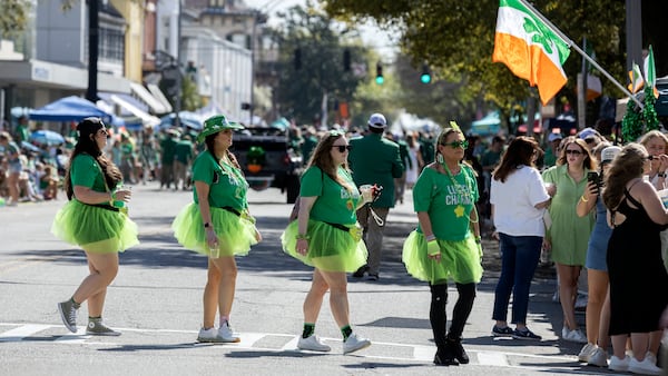 Dressed in green tutus a group of visitors cross Broughton Street in historic downtown Savannah during a gap in the St. Patrick's Day parade on March 16, 2024, in Savannah, Ga.  (AJC Photo/Stephen B. Morton)