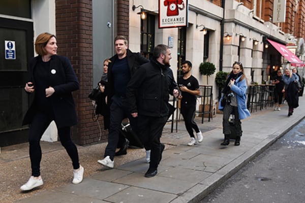 People hurriedly leave the area after reports of shots being fired on London Bridge Friday in London, England.