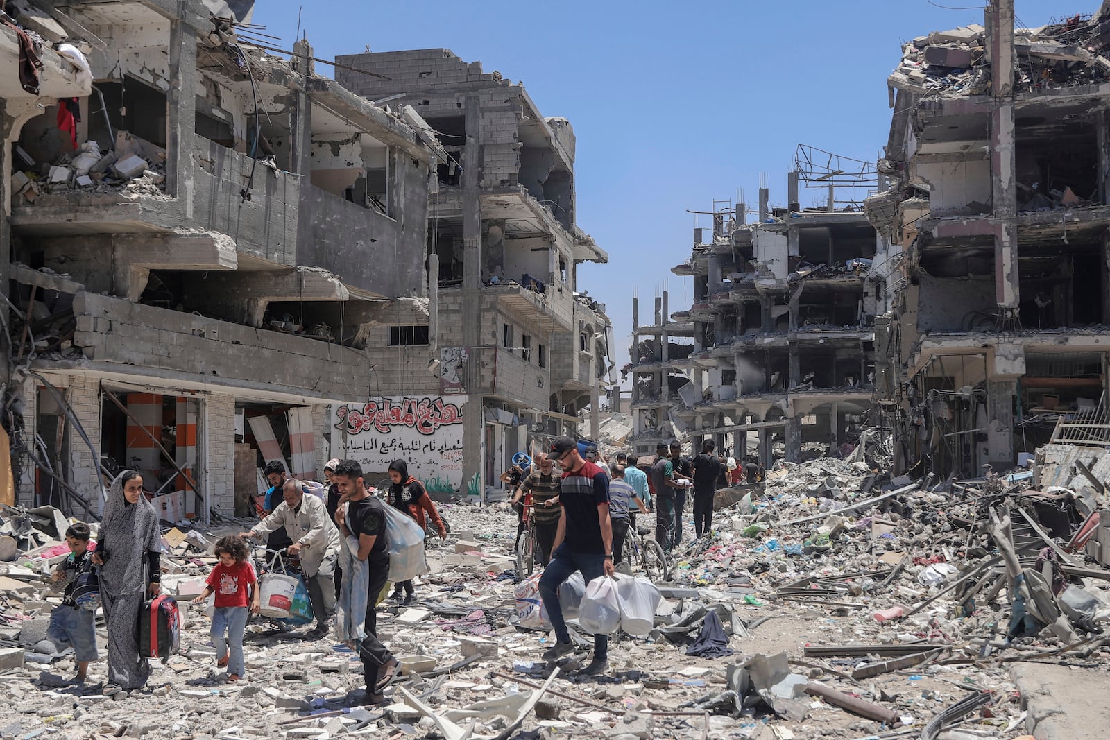 FILE - Palestinians walk through the destruction in the wake of an Israeli air and ground offensive in Jebaliya, northern Gaza Strip, on May 30, 2024. (AP Photo/Enas Rami, File)