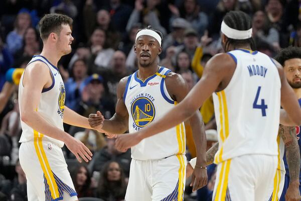 Golden State Warriors forward Jimmy Butler III, center, reacts with center Quinten Post, left, and guard Moses Moody (4) after scoring and being fouled during the first half of an NBA basketball game against the Detroit Pistons in San Francisco, Saturday, March 8, 2025. (AP Photo/Jeff Chiu)