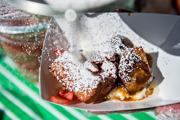 The guys at Dish Dive add powdered sugar to their pork belly and French toast with grits offering during the Atlanta Brunch Festival at Fourth Ward Park in Atlanta on Saturday, March 5, 2016. JONATHAN PHILLIPS / SPECIAL