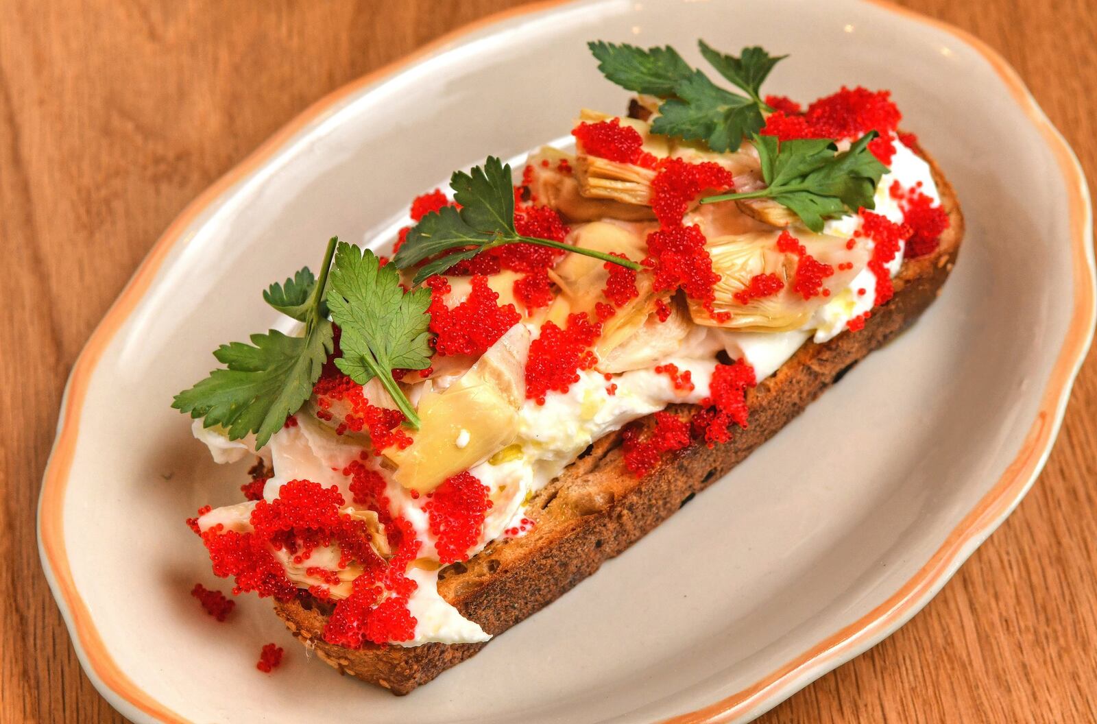 Burrata Toast appetizer with artichokes and  caviar. CONTRIBUTED BY CHRIS HUNT PHOTOGRAPHY