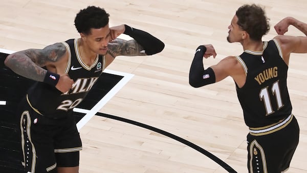 Hawks forward John Collins (left) and guard Trae Young flex after teaming up for a score against the Oklahoma City Thunder Thursday, March 18, 2021, at State Farm Arena in Atlanta. (Curtis Compton / Curtis.Compton@ajc.com)