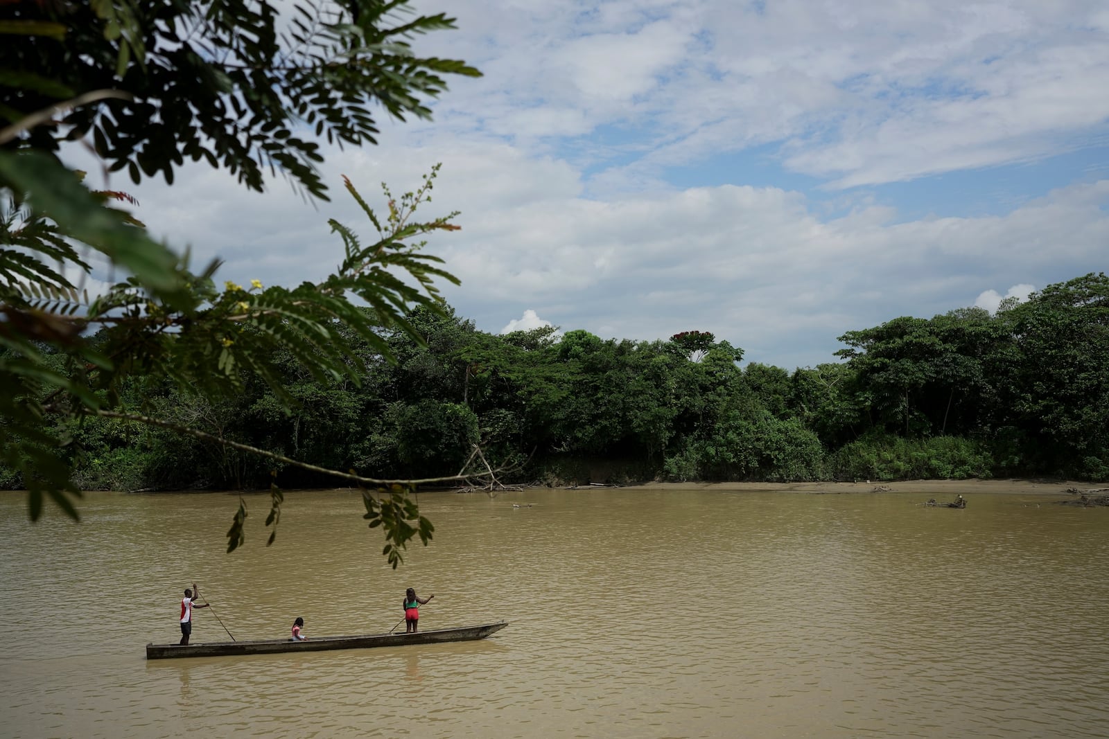 People maneuver on the Quito River, near Paimado, Colombia, Monday, Sept. 23, 2024. (AP Photo/Ivan Valencia)