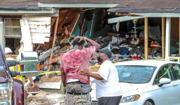 June 30, 2022 Coweta County: Leonard Rush, son of deceased (left) is comforted by Sara Brooks (right) after a woman died after a vehicle with a 14-year-old at the wheel crashed into her house following a police pursuit that reached speeds over 130 mph Thursday morning, June 30, 2022 the Coweta County Sheriff’s Office confirmed. A deputy first encountered the vehicle around 2 a.m. as he was patrolling the area of Highway 54 and Johnson Road, the sheriff’s office said in a news release. The vehicle had failed to dim its headlights, so the deputy turned around to follow the vehicle and attempted a traffic stop. The vehicle sped off and the deputy eventually lost sight of it, the news release states. As the deputy continued down Johnson Road, he saw a person standing in a yard and asked the person if they’d seen a speeding vehicle. The person told the deputy they had seen the vehicle, and they believed it had crashed into a neighboring house. The deputy went to the house and confirmed the vehicle had crashed into it, the release states. He also found the 14-year-old believed to have been the driver. The sheriff’s office did not publicly identify the teen. A man and a woman who were inside the house at the time of the crash were taken to a hospital, the release states. The woman died a short time later. Her identity was not immediately released by police, and they did not disclose the man’s condition. The teen also was taken to a hospital for evaluation and then taken to a youth detention center. He faces a charge of homicide by vehicle, which will be investigated by the Georgia State Patrol, and other traffic offenses that will be filed by the sheriff’s office. At the scene of the crash and once the sun rose, family and friends convened to comfort the woman’s husband and son as news of the tragedy began to spread among the small, tight-knit community. “There’s no words to describe it. It’s just unbelievable ... This was some place people were living, and it looks like, it looks like that,” family friend and neighbor Sara Brooks said quietly upon seeing the aftermath of the crash. Nearly the entire facade of the home was destroyed, and sheathing was already being installed to close the large opening into what appeared to be the living room and a bedroom. A mattress could be seen poking through the rubble, and the porch deck and railing appeared to be unstable. Brooks, who said she knew the victim all of her life, described her as very kind, gentle and loved her family. “She has a child that is in a wheelchair, and she took very good care of that child all of the time — her family, period. She took care of all of them,” Brooks said. No other details were released by police about the man who also was injured or why or how the 14-year-old obtained the vehicle and was driving at such an hour. (John Spink / John.Spink@ajc.com)


