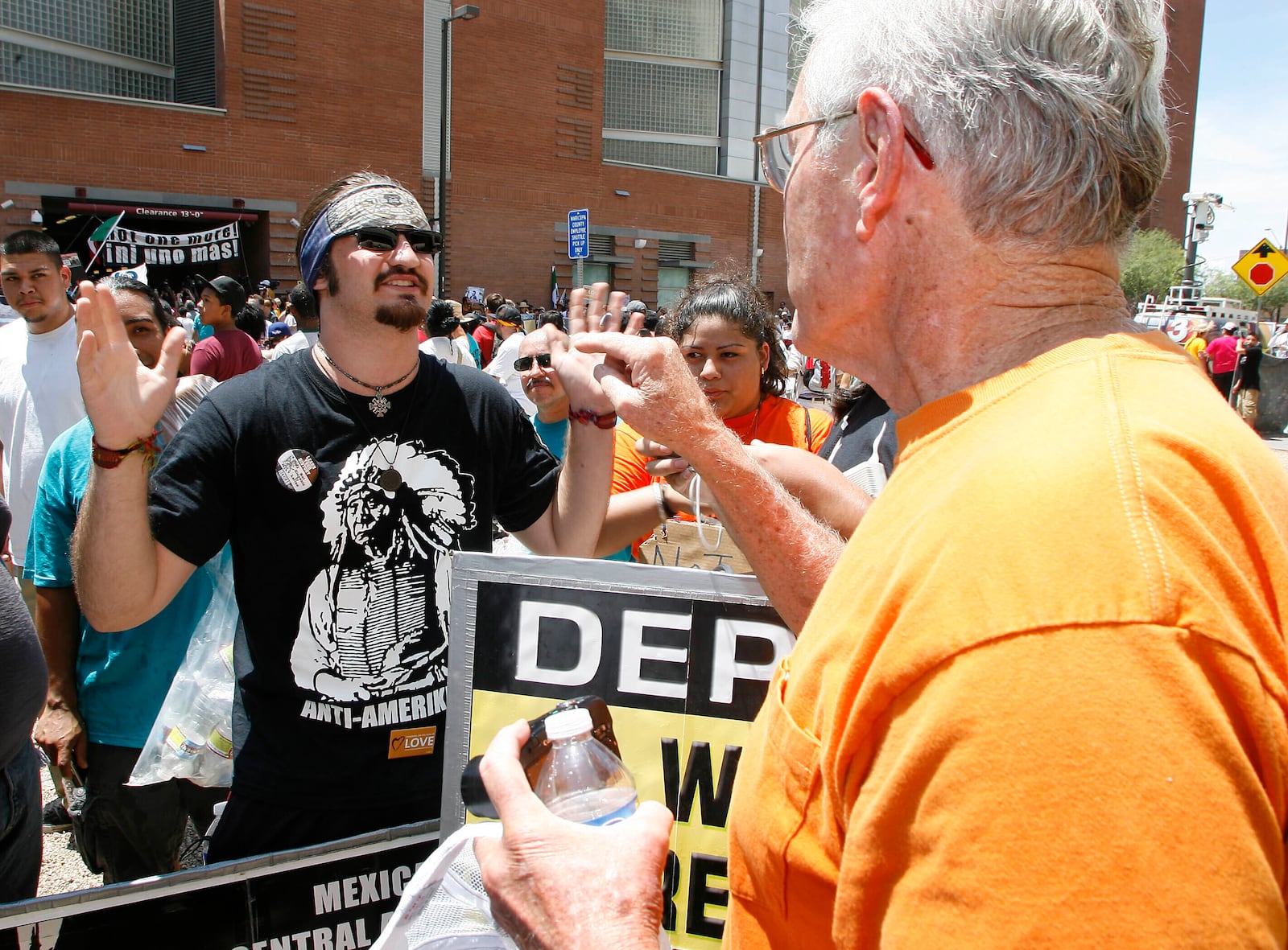 FILE - Nineteen year old Cuaghtlatohuac Haitzilopoch, left, has a heated conversation with a supporter of the new immigration-enforcement law during a protest of Arizona's SB1070 in front of Maricopa County Sheriff Joe Arpaio's office, July 29, 2010 in Phoenix. (AP Photo/Ralph Freso, File)