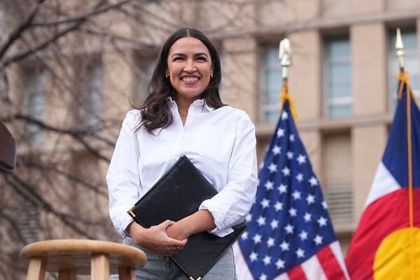 Rep. Alexandria Ocasio-Cortez, D-N.Y., smiles after speaking during a stop of their "Fighting Oligarchy" tour that filled Civic Center Park, Friday, March 21, 2025, in Denver. (AP Photo/David Zalubowski)