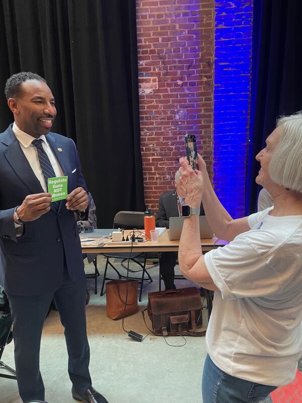 Atlanta Mayor Andre Dickens poses backstage with a sticker that reads "Regulate Guns not Women" at a campaign stop for President Joe Biden in Atlanta on March 9, 2024.