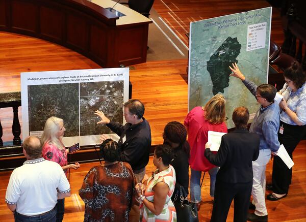 Attendees of an August town hall examine maps showing estimated cancer risks and modeled ethylene oxide concentrations around Covington’s BD plant — the results of mathematical modeling by the Georgia Environmental Protection Division. The models were based in part on the company’s self-reported emissions figures, and Jason McCarthy, of the Covington area’s Stop EtO chapter, said recent air testing results call the data into question. CURTIS COMPTON / CCOMPTON@AJC.COM