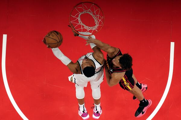 Denver Nuggets guard Russell Westbrook (4) is defended by Atlanta Hawks guard Dyson Daniels (5) as he shoots a basket during the first half of an NBA basketball game Sunday, Dec. 8, 2024, in Atlanta . (AP Photo/John Bazemore)