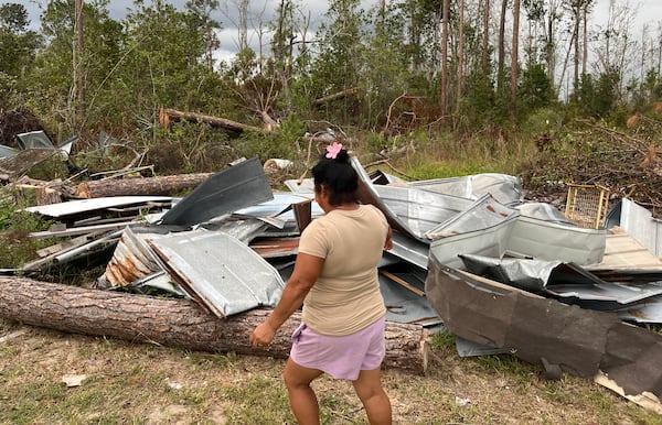 Eduviges, a Lake Park-based farmworker from Mexico, surveys the scraps of metal that once made up her roof.