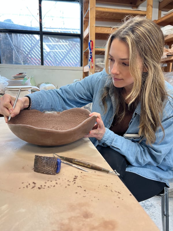 A student adds detail to her work at Atlanta Clay Works in Kirkwood. (Courtesy of Atlanta Clay Works)