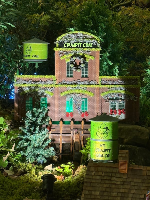 A detailed miniature holiday village lines a toy train track at 'Garden Lights, Holiday Nights' at Atlanta Botanical Gardens. Among the buildings was a miniature of the Crumpit Coal Factory from "The Grinch Who Stole Christmas."