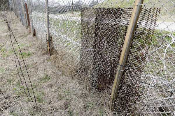 February 2017 — Patches of metal seen bolted to the fence along the United States Penitentiary in Atlanta to cover holes that minimum security inmates created to sneak out and back into the prison. (DAVID BARNES / SPECIAL)