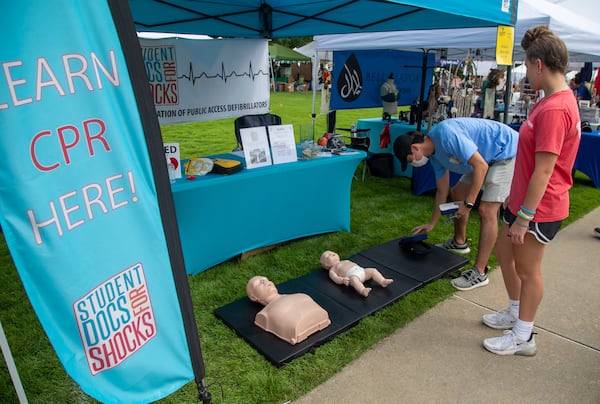 In this file photo, PCOM (Philadelphia College of Osteopathic Medicine) student Danny Kim (left) demonstrates how to perform CPR and use a defibrillator on an infant doll to Ashley Benton (age 15) at the Student Docs for Shocks booth during the Suwanee Fest in Suwanee. PHIL SKINNER FOR THE ATLANTA JOURNAL-CONSTITUTION.