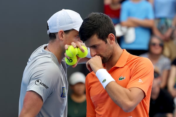 FILE - Canada's Vasek Pospisil and Serbia's Novak Djokovic talk tactics during their double match against during their Round of 32 match at the Adelaide International Tennis tournament in Adelaide, Australia, Jan. 2, 2023. (AP Photo/Kelly Barnes, File)