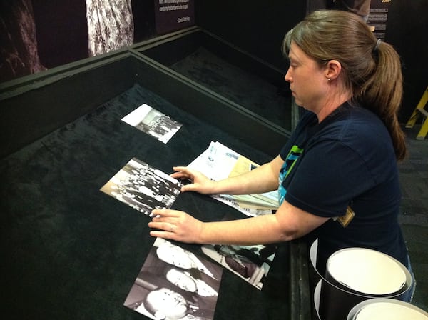 Leah Berry, a museum technician at the King Historic Site, installs photographs and documents that will be on display in the exhibit. Among them are photographs and reflections from his family when he won the Nobel Peace Prize.