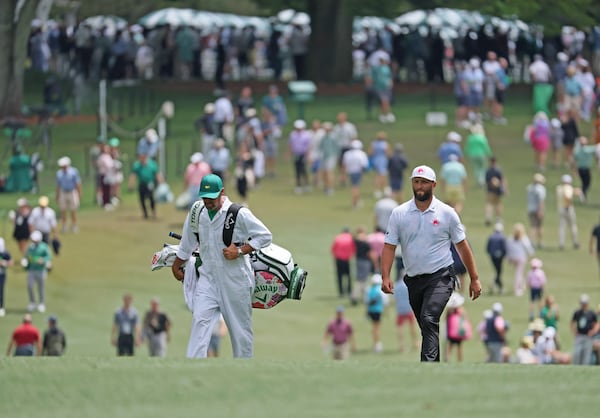 Defending Masters Champion Jon Rahm walks up the first fairway with caddie Adam Hayes at the 2024 Masters Tournament at Augusta National Golf Club, Thursday, April 11, 2024, in Augusta, Ga. Jason Getz / Jason.Getz@ajc.com)
