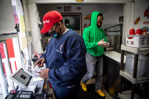 Young entrepreneur Mason Wright (left) and Ayden Whitely put together a food order at Mason's Super Dogs restaurant in Stonecrest. STEVE SCHAEFER FOR THE AJC