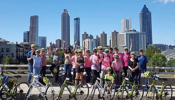 Bicycle Tours of Atlanta patrons pose for a picture in front of the Atlanta skyline.