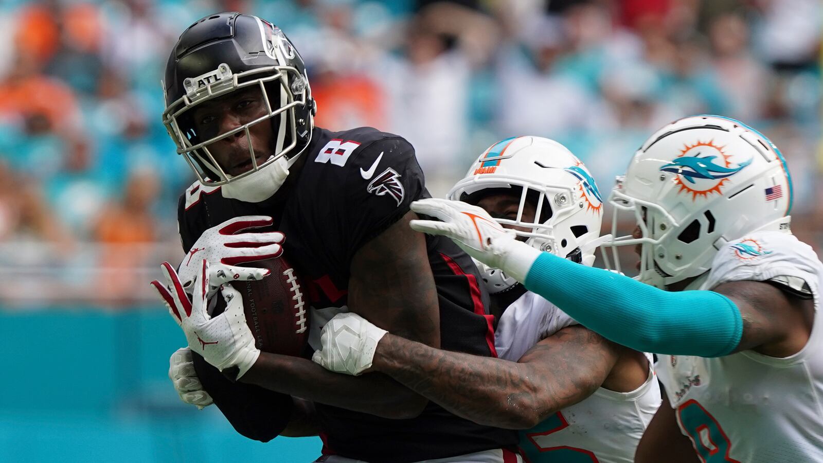 Falcons tight end Kyle Pitts (8) makes a catch, defended by Miami Dolphins cornerback Xavien Howard (25) and Miami Dolphins free safety Jevon Holland (8) late  in the second half Sunday, Oct. 24, 2021, in Miami Gardens, Fla. (Hans Deryk/AP)