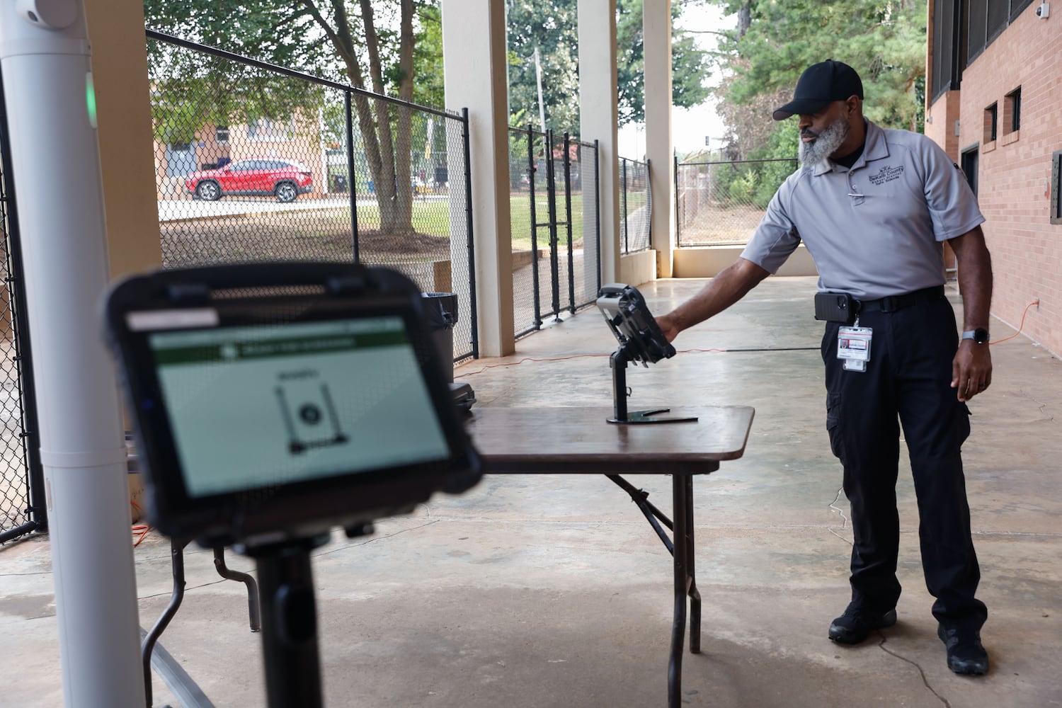 Frederick Johnson, an analyst with the DeKalb County Safe Schools program, uses the monitoring tablet for the Evolv weapons detection system at Adams Stadium on Thursday, Aug. 15, 2024. The system has already been implemented in many DeKalb schools and will be expanding to football stadiums. (Natrice Miller/ AJC)