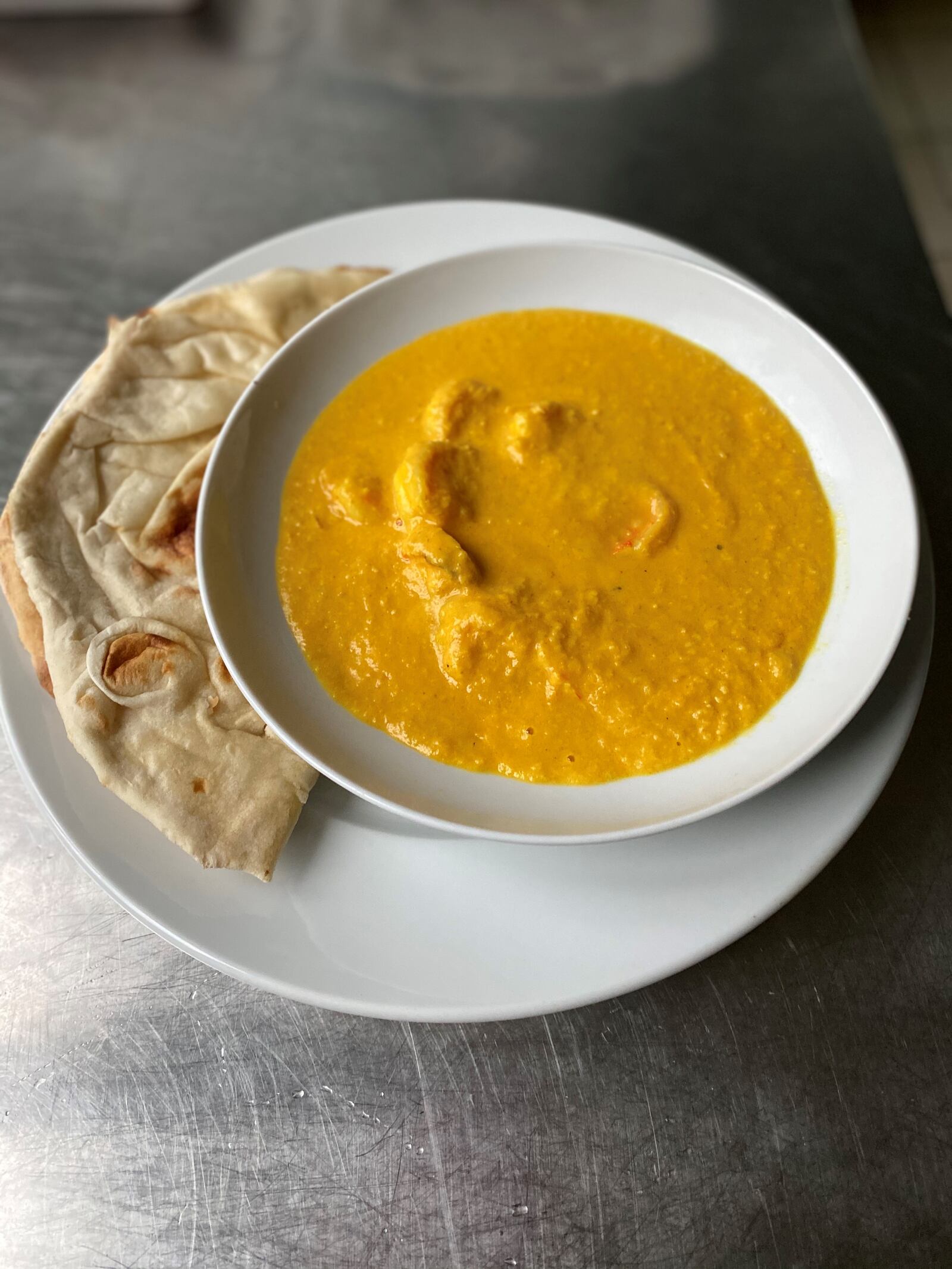 Goan shrimp curry is seen here with an order of naan from Cafe Bombay. Wendell Brock for The Atlanta Journal-Constitution