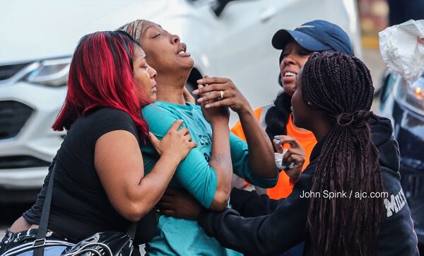 Sanmarian McClain (center) mourns the loss of her daughter Jessica Daniels, who was killed when a stray bullet flew into her home while she was sleeping.