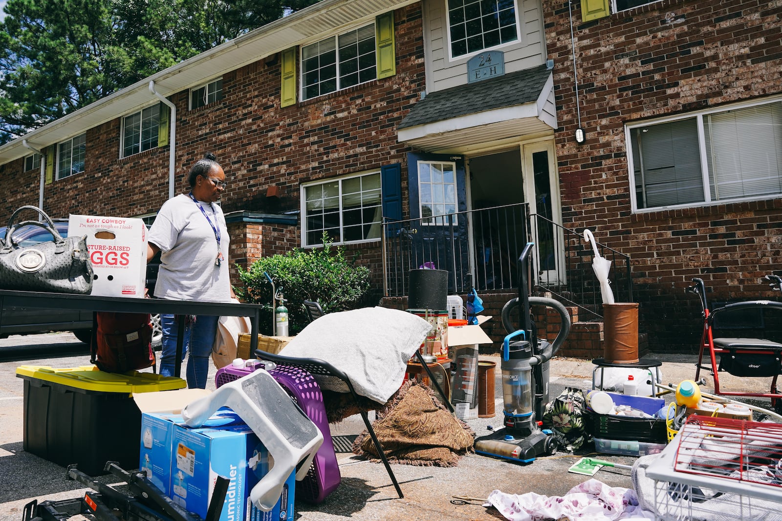 Constance Alford of Atlanta looks over her belongings after workers hauled them to the parking lot during a July eviction from her Pavilion Place apartment. She said she had been living there for 10 years. (Olivia Bowdoin for The Atlanta Journal-Constitution) 