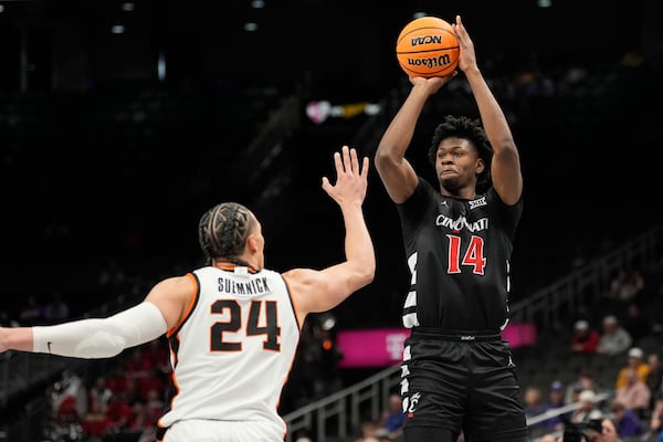 Cincinnati's Tyler Betsey (14) shoots over Oklahoma State's Patrick Suemnick (24) during the first half of an NCAA college basketball game in the first round of the Big 12 Conference tournament, Tuesday, March 11, 2025, in Kansas City, Mo. (AP Photo/Charlie Riedel)