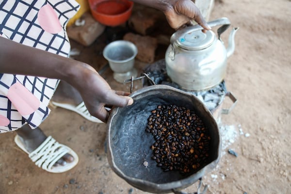 A food vendor fries roasted coffee beans in Yambio, South Sudan on Monday, Feb. 17, 2025. (AP Photo/Brian Inganga)