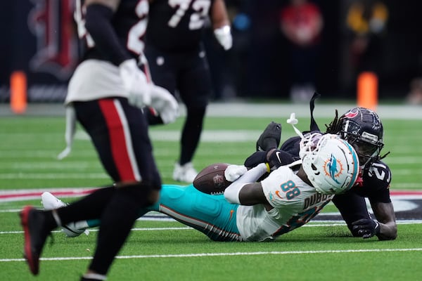 Miami Dolphins wide receiver Grant DuBose (88) is brought down by Houston Texans safety Calen Bullock (21) on a play that left DuBose injured, during the second half of an NFL football game Sunday, Dec. 15, 2024, in Houston. (AP Photo/Eric Christian Smith)