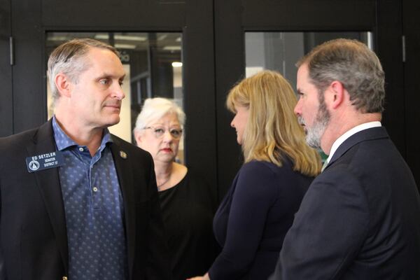 State Sen. Ed Setzler, a Republican from Acworth (left), speaks to attorney Chuck Boring (right) while the Cobb County Board of Elections deliberates on whether to disqualify candidate Alicia Adams on Friday, March 15, 2024, in Marietta. Cobb GOP Chair Salleigh Grubbs talks with Adams in the background. (Taylor Croft/taylor.croft@ajc.com)