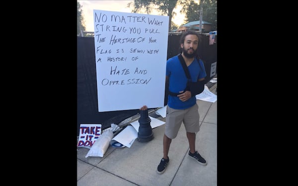 Daniel Dobry, 31, of Kennesaw, poses with the sign he marched with to city hall in favor of removing the city's Confederate flag downtown.