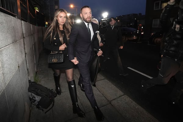 Mixed martial arts fighter Conor McGregor, right, and partner Dee Devlin outside the High Court in Dublin Friday, Nov. 22, 2024, where he is appearing for a personal injury case against him. (Brian Lawless/PA via AP)