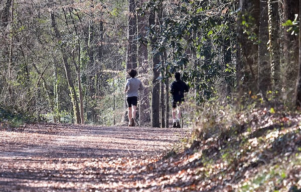 Runners on Saturday, Feb. 22, 2025 enter the University of Georgia trails where Laken Riley, a 22-year-old nursing student, was killed one year ago. Runners and walkers paid tribute to Riley by walking or running for 22 minutes on the one-year anniversary of her death, the first homicide on the campus in more than two decades. 
(Nell Carroll for The Atlanta Journal-Constitution)