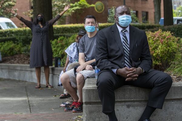 Dennis Parmer (front), of Woodstock, watches the funeral service for Rayshard Brooks as it is streamed outside of Ebenezer Baptist Church in Atlanta’s Sweet Auburn community, Tuesday, June 23, 2020. (ALYSSA POINTER / ALYSSA.POINTER@AJC.COM)