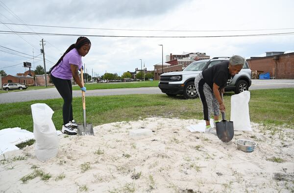 Shavon Kier (left) and Ora Hagins, both of Valdosta, fill their sand bags in preparation for Hurricane Helene near downtown Valdosta, Wednesday, September 25, 2024. Hurricane Helene is on the way. The powerful storm, barreling through the Gulf of Mexico on its way to the Florida Panhandle, was upgraded from a tropical storm to a hurricane late Wednesday morning. The latest system to threaten the Gulf Coast is projected to arrive in Florida by Thursday evening, according to the National Hurricane Center. (Hyosub Shin / AJC)