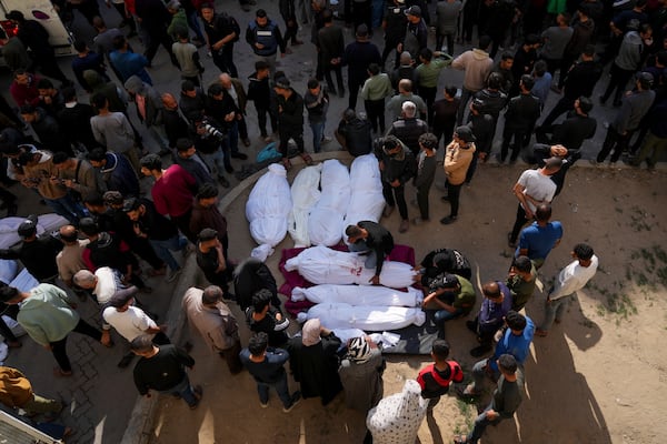 People gather around the bodies of Palestinians who were killed in an Israeli army airstrikes as they are brought to the Al-Ahli Hospital in Gaza City, Tuesday, March 18, 2025. (AP Photo/Abdel Kareem Hana)