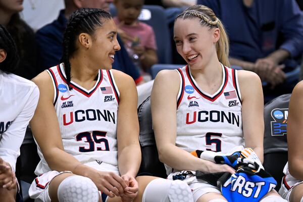 UConn guards Azzi Fudd (35) and guard Paige Bueckers (5) smile at each other on the bench in the second half against Arkansas State iin a first round of the NCAA college basketball tournament, Saturday, March 22, 2025, in Storrs, Conn. (AP Photo/Jessica Hill)