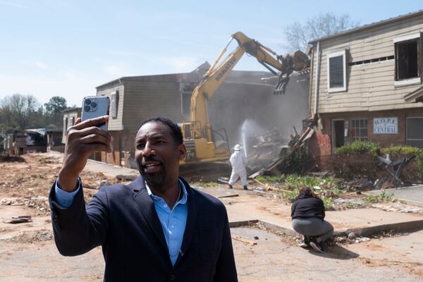 Atlanta Mayor Andre Dickens shoots a video as demolition work begins on the former Forest Cove Apartments.