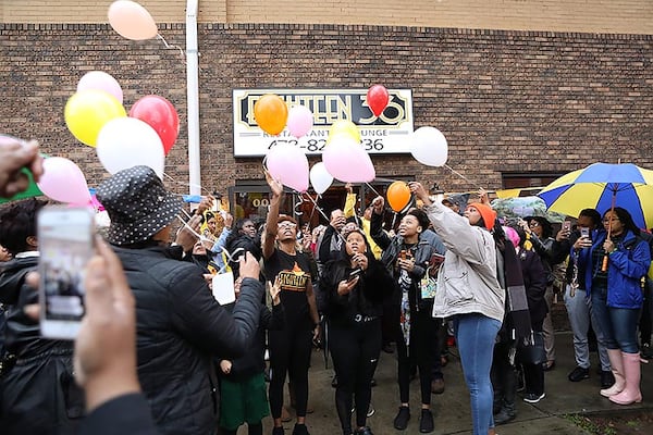 Mourners release balloons in memory of Anitra Gunn in front at the Eighteen36 Restaurant and Lounge, where she worked, in Fort Valley on Thursday, February 20, 2020. (Photo/Leah Yetter for the AJC)