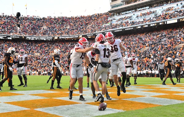 Georgia quarterback Stetson Bennett (13) celebrates with teammates after scoring a touchdown in the first half Nov. 13, 2021, at Neyland Stadium in Knoxville, Tenn. (Hyosub Shin / Hyosub.Shin@ajc.com)