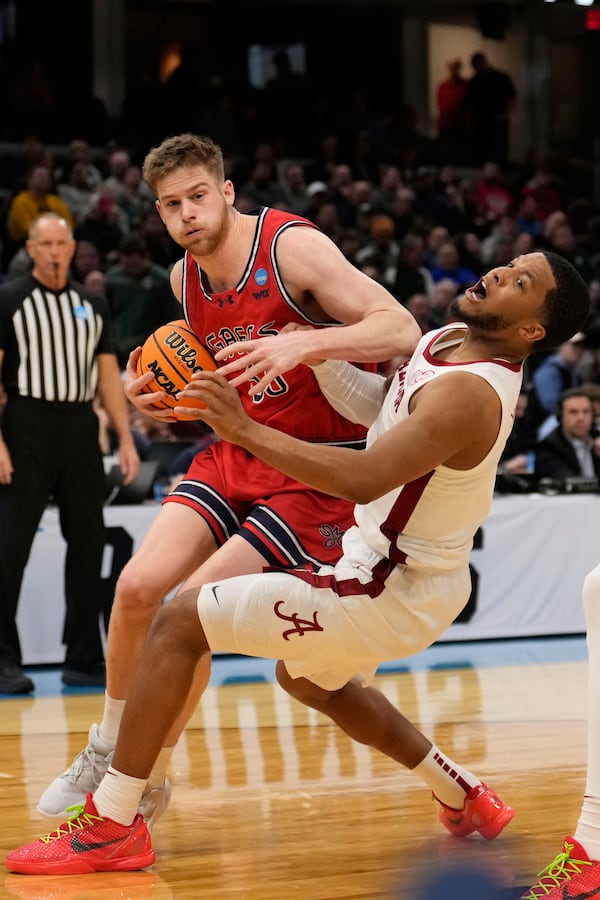 Saint Mary's forward Luke Barrett, left, and Alabama guard Chris Youngblood, right, collide in the second half in the second round of the NCAA college basketball tournament, Sunday, March 23, 2025, in Cleveland. (AP Photo/Sue Ogrocki)