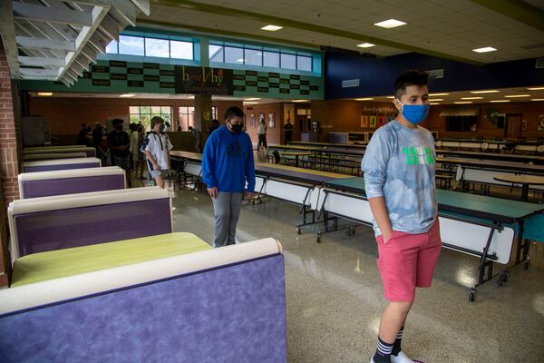 08/20/2020 - Cartersville, Georgia - Students stand socially distant in the cafeteria as they purchase their school lunches at Cartersville Middle School in Cartersville, Thursday, August 20, 2020. Students eat in their classrooms. This will allow the school to better contact trace, if a student tests positive for COVID-19.  (ALYSSA POINTER / ALYSSA.POINTER@AJC.COM)