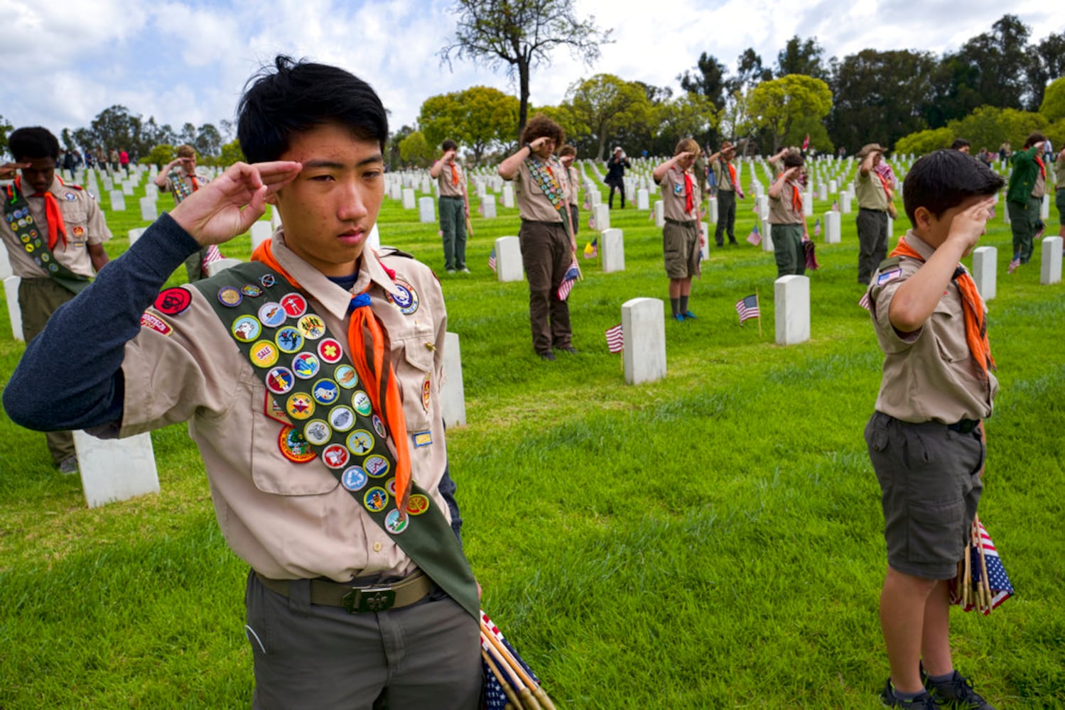 scouts place flags at veteran graves to honor memorial day