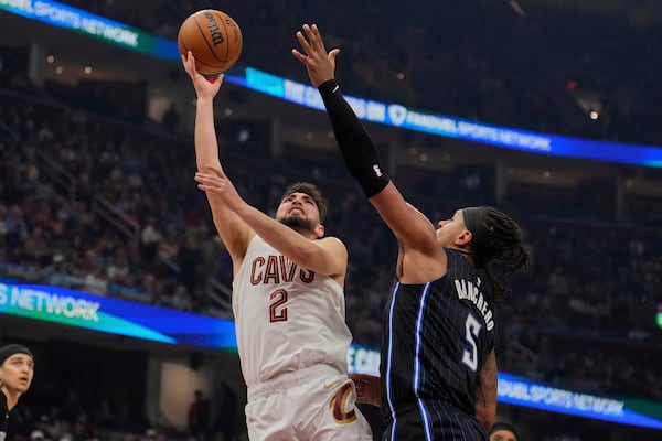 Cleveland Cavaliers guard Ty Jerome (2) shoots next to Orlando Magic forward Paolo Banchero (5) in the first half of an NBA basketball game Sunday, March 16, 2025, in Cleveland. (AP Photo/Sue Ogrocki)