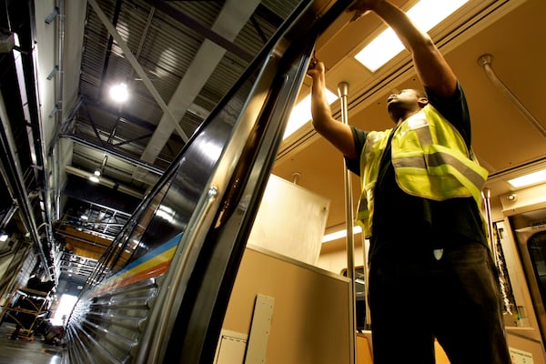 A MARTA employee makes adjustments to a door on a rehabilitated rail car at the MARTA Avondale Yard in Decatur, Ga. on Tuesday, July 11, 2006. (ALLEN SULLIVAN/Special)